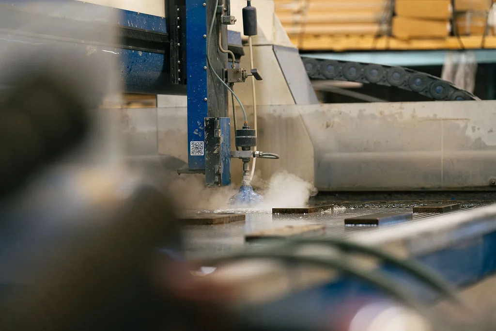 Waterjet cutting table processing material in the FES fabrication shop
